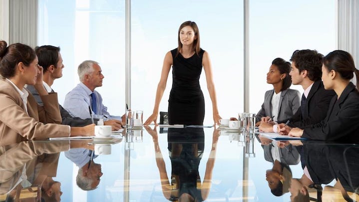 A female manager in a meeting standing talking